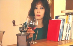 赤ワインのグラスを置く愛人の女